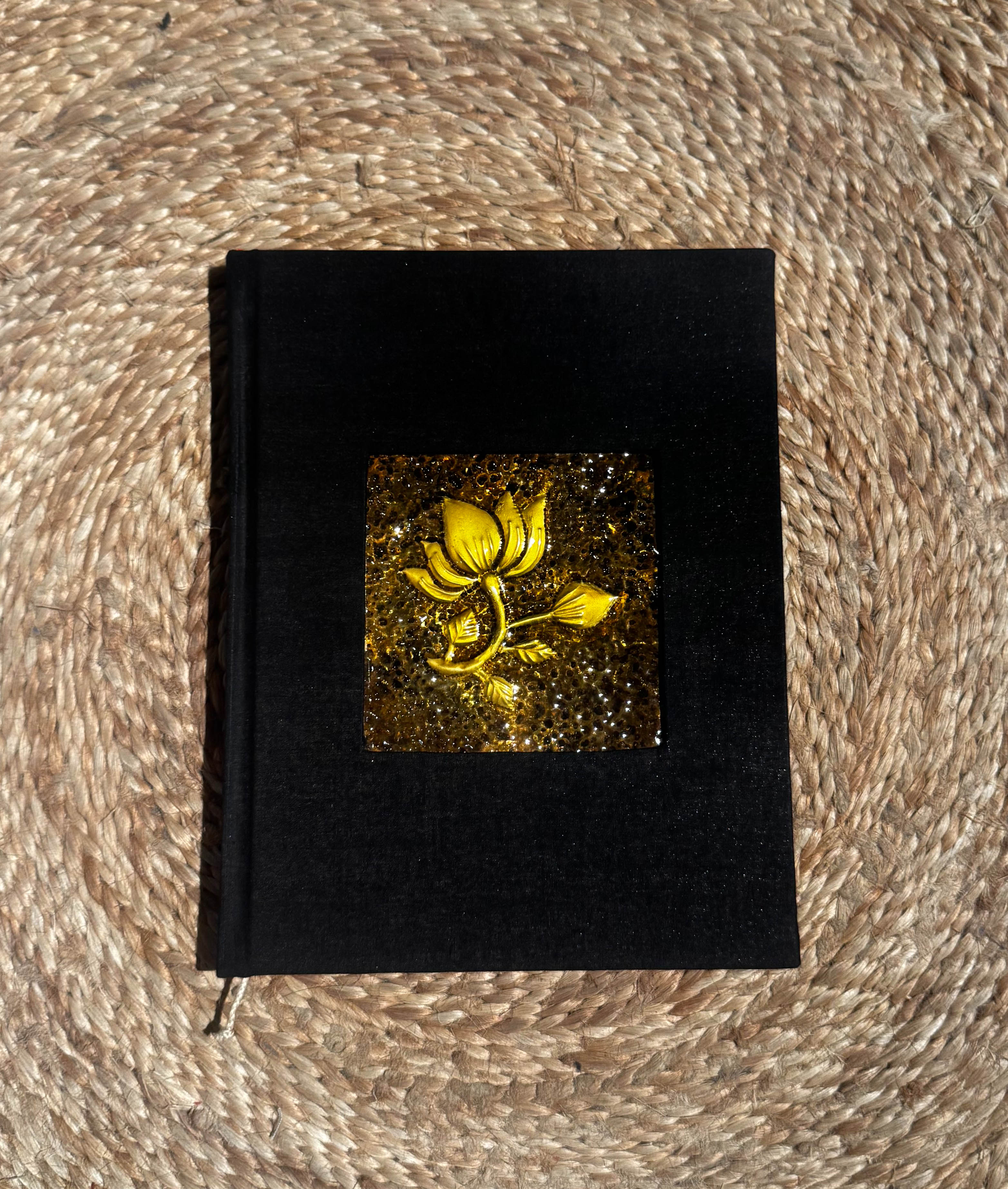 Black journal with a patinated brass flower inlay